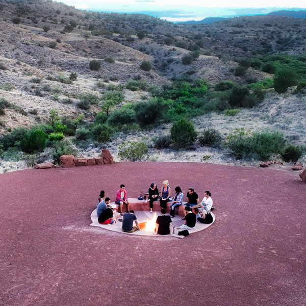Residents at The Sanctuary sitting in a circle around a fire pit