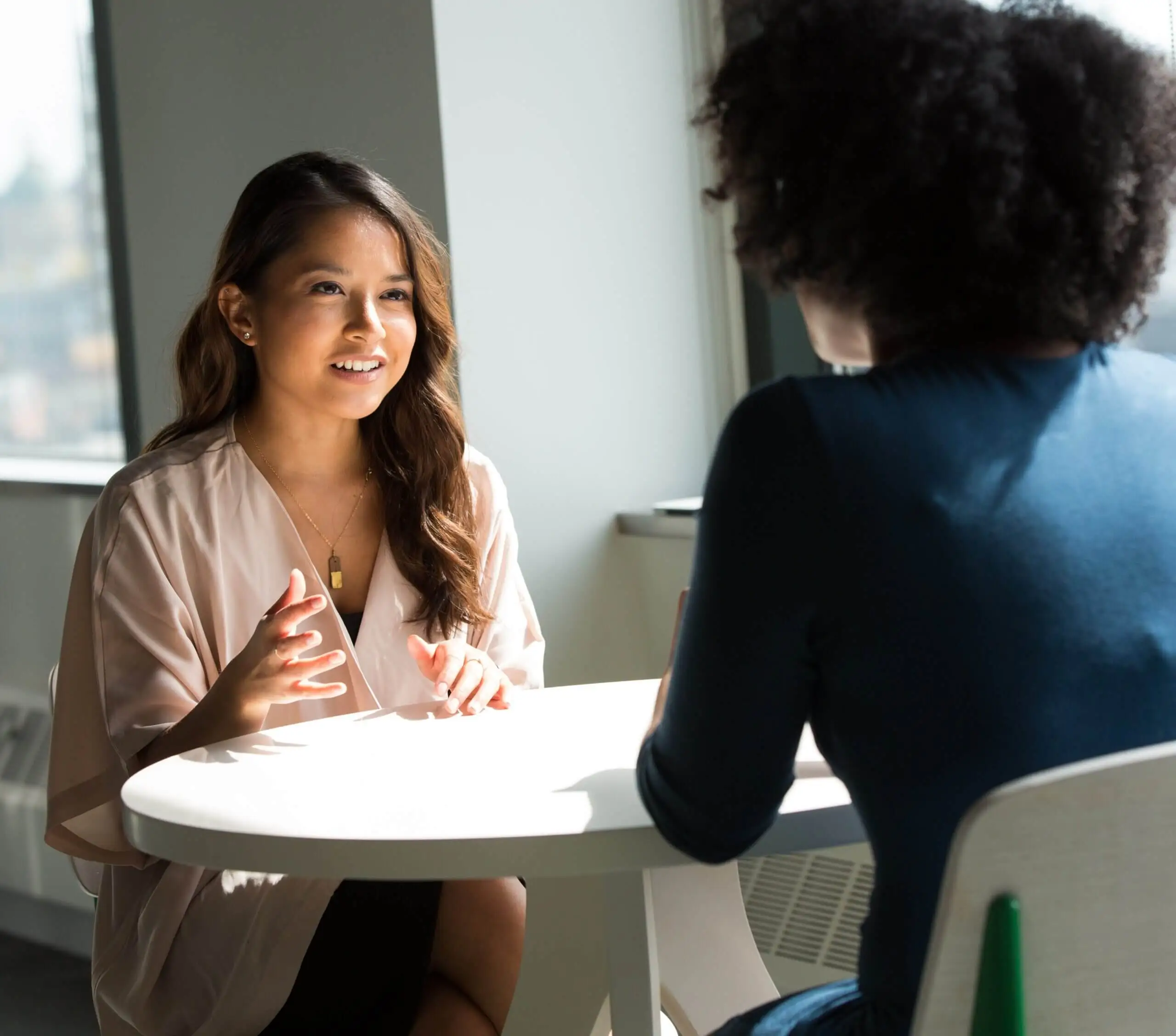 Two women talking at a table together